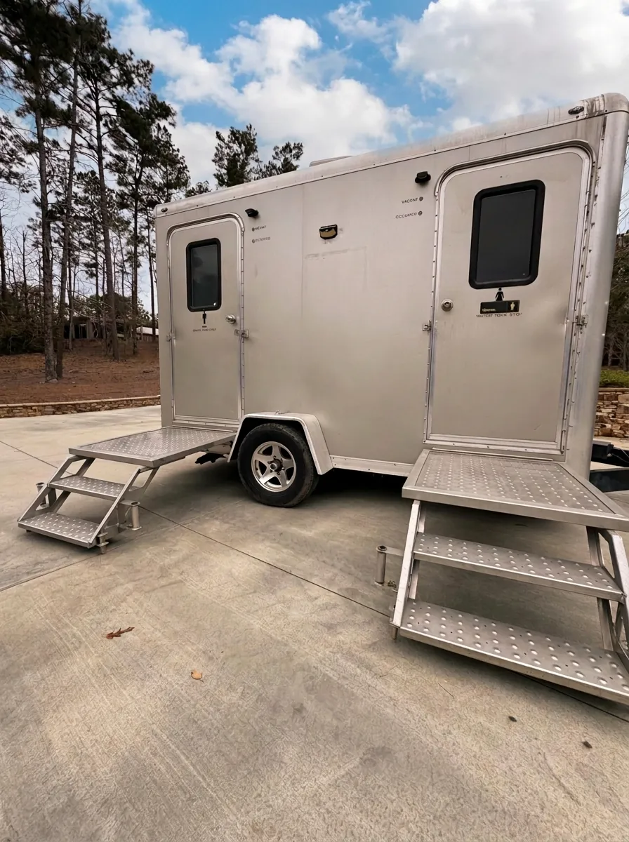 Two-station restroom trailer with separate men's and women's entrances and aluminum entry steps